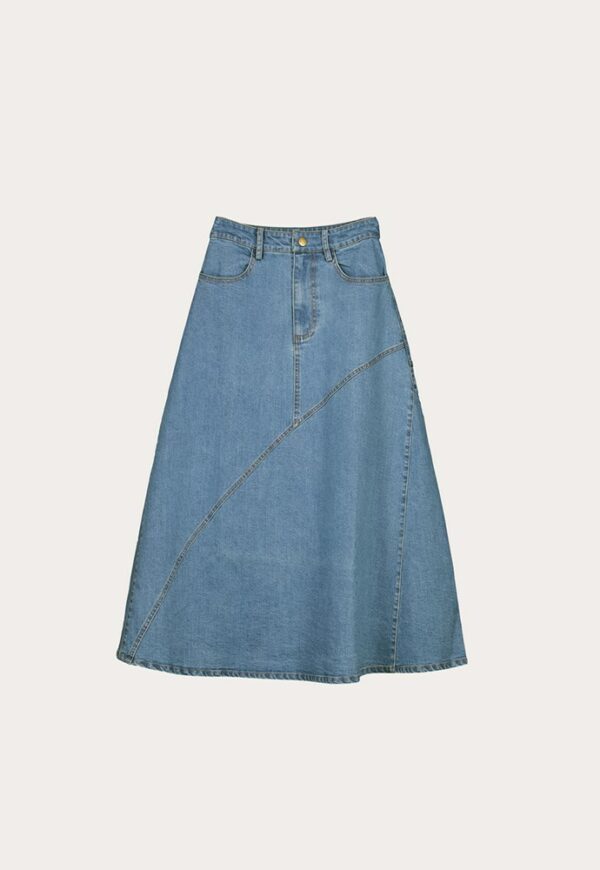 Flat Lay of Nancybird Aurora Skirt in denim—A‑line midi skirt with waist tie, front slant patch pockets, contrast stitching and slit back, on a neutral background.