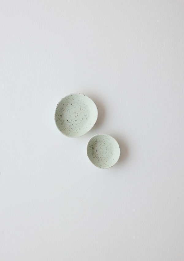 Pair of pale pistachio high-fired porcelain dipping bowls in pistachio with sculptural curves and speckled glaze.