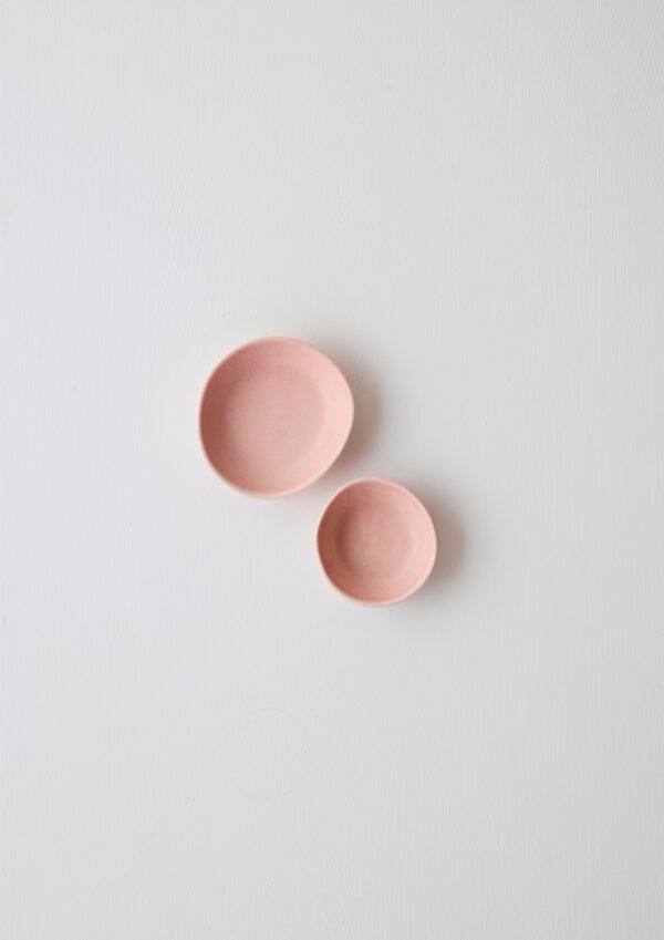 Pair of pale pistachio high-fired porcelain dipping bowls in strawberry with sculptural curves and speckled glaze.