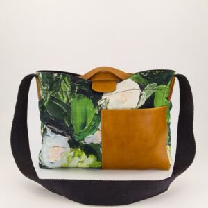 Nancybird Assemble Tote in Garden print — crossbody canvas bag with green botanical lino design, gold-toned accents and adjustable strap, styled against neutral backdrop