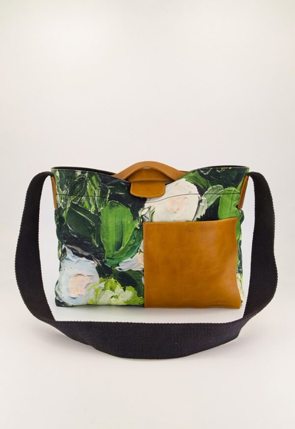Nancybird Assemble Tote in Garden print — crossbody canvas bag with green botanical lino design, gold-toned accents and adjustable strap, styled against neutral backdrop