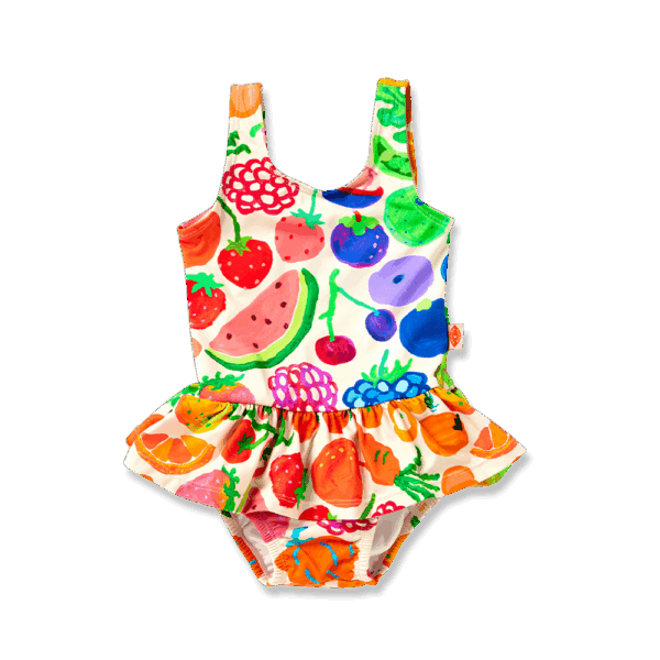 Model wears Halcyon Nights Baby Frill Bather in Eat The Rainbow print—frill-trimmed swimsuit with vibrant rainbow artwork and built-in nappy liner for babies