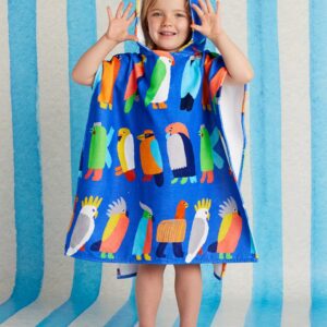Model wears Halcyon Nights Kids Hooded Towel in Flamin' Galahs print—poncho-style cotton towel with hood, white underside, and colourful pink galahs by Min Pin