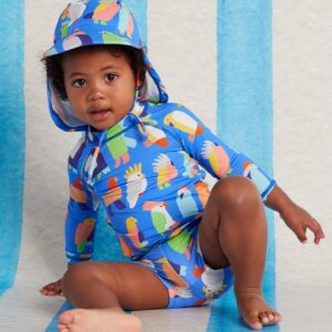 Model wears Halcyon Nights Long Sleeve Rash Vest in Flamin' Galahs print—baby swim top with pink galahs, full-length sleeves, and UPF 50+ recycled fabric