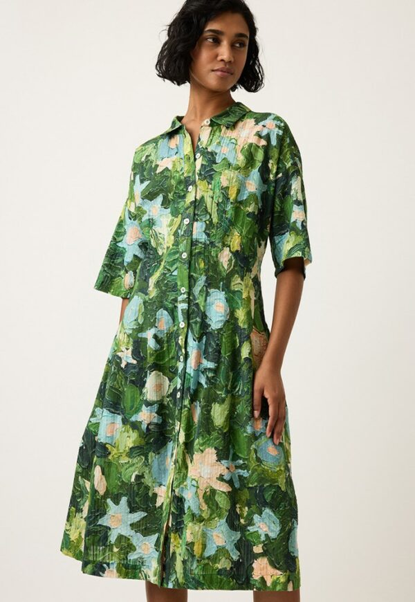 Model wears Nancybird Paloma Short Sleeve Dress in Garden print—A‑line cotton shirtdress with collared neckline, pintuck waist detail and Emily Wright’s green botanical artwork