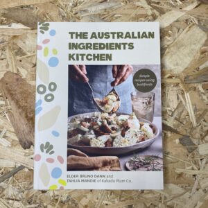 Cover of The Australian Ingredients Kitchen by Elder Bruno Dann and Tahlia Mandie, featuring a vibrant array of native Australian ingredients and dishes, reflecting the book's focus on bush foods and cultural