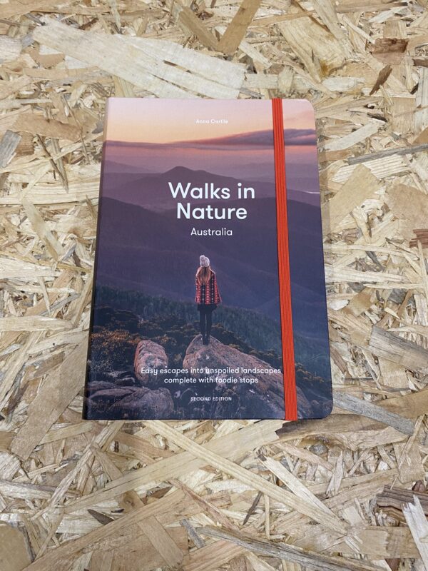 Cover of Walks in Nature: Australia (2nd Edition) by Anna Carlile, featuring a scenic Australian landscape with coastal cliffs and lush greenery, representing the diverse trails included in the guide.