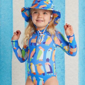 Model wears Halcyon Nights Long Sleeve Zip Bather in Flamin' Galahs print—kids swimwear with full sleeves, front zip, pink galah artwork, and UPF 50+ recycled fabric