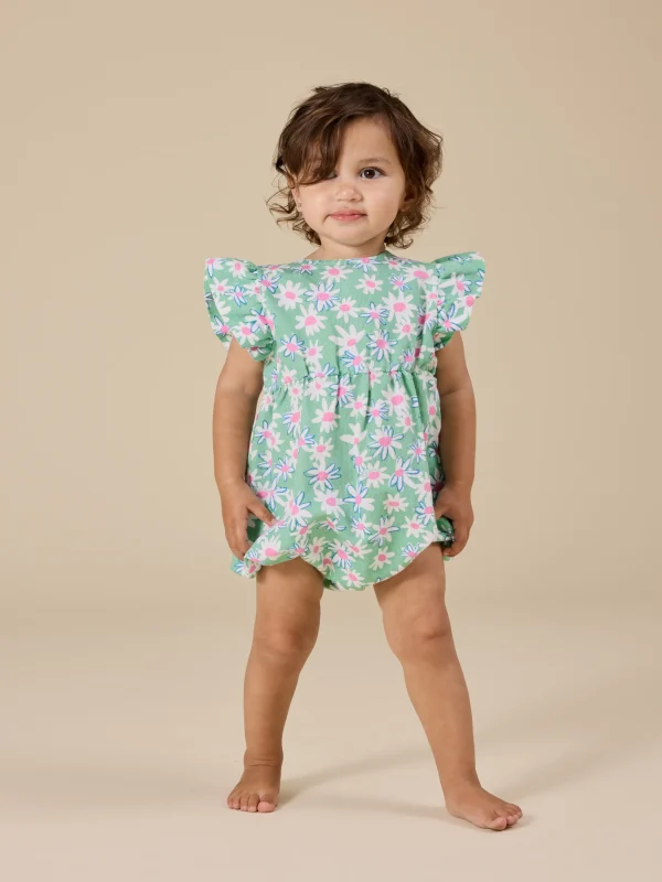 Baby wearing Goldie & Ace Daisy Patch Lani Romper in moss green, with frill sleeves and leg snaps.